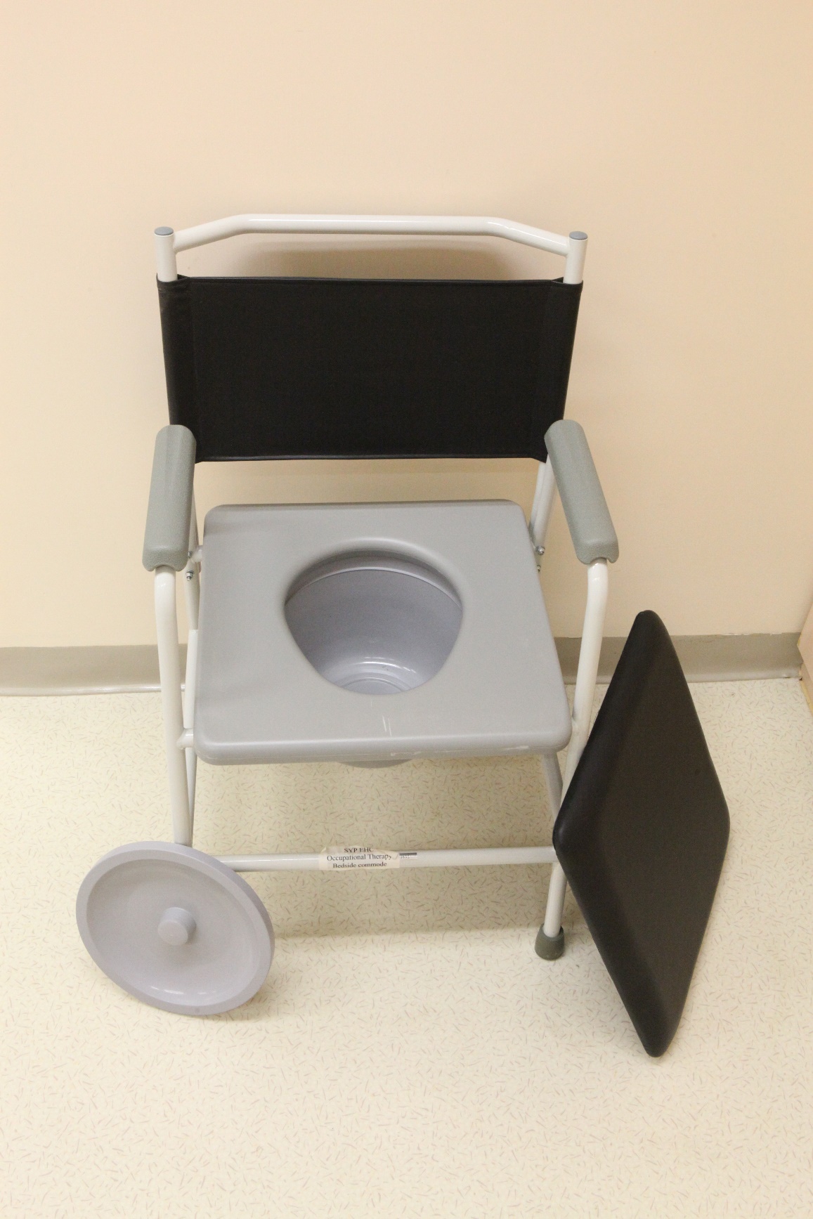 The diagram shows a stationary commode chair with a removable lid next to it.  After removing the lid, there is a toilet seat and a plastic bucket that can be pulled out for easy cleansing. 