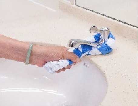 wringing a towel that is entangled over the water tap, by one-hand technique
