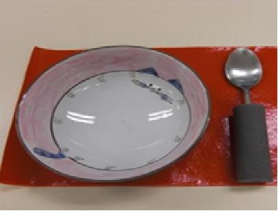 一张红色防滑胶垫，上面放着一只碟和一只汤匙
